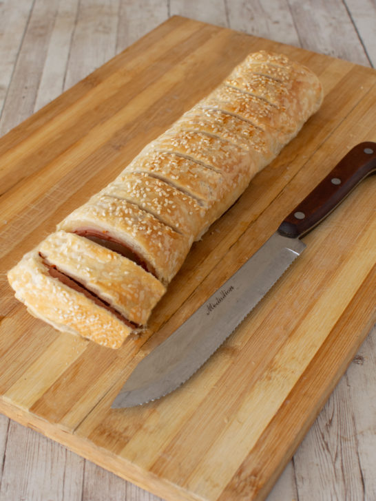 Deli roll on a bread board, sliced