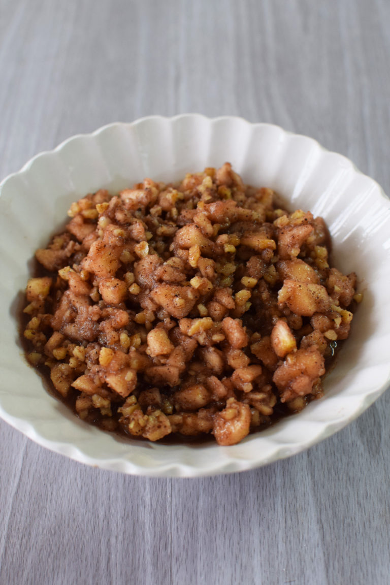Easy charoset in a white bowl on a white wood table