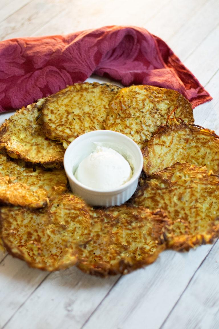 Easy Latkes on a plate around a cup of sour cream