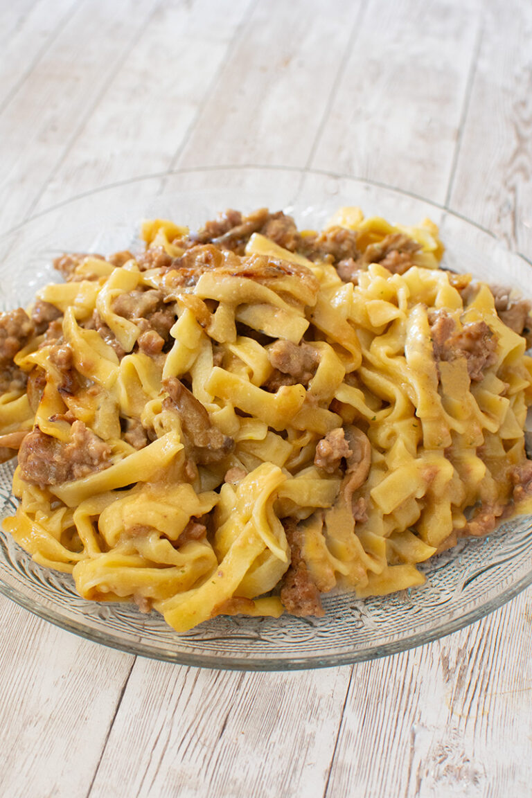Ground beef stroganoff in a clear bowl on a white wood table