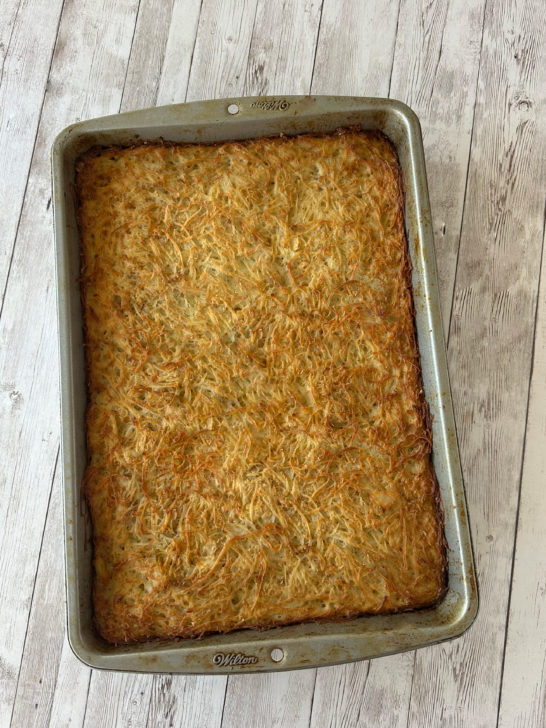 potato kugel for passover in a pan on a white wood table