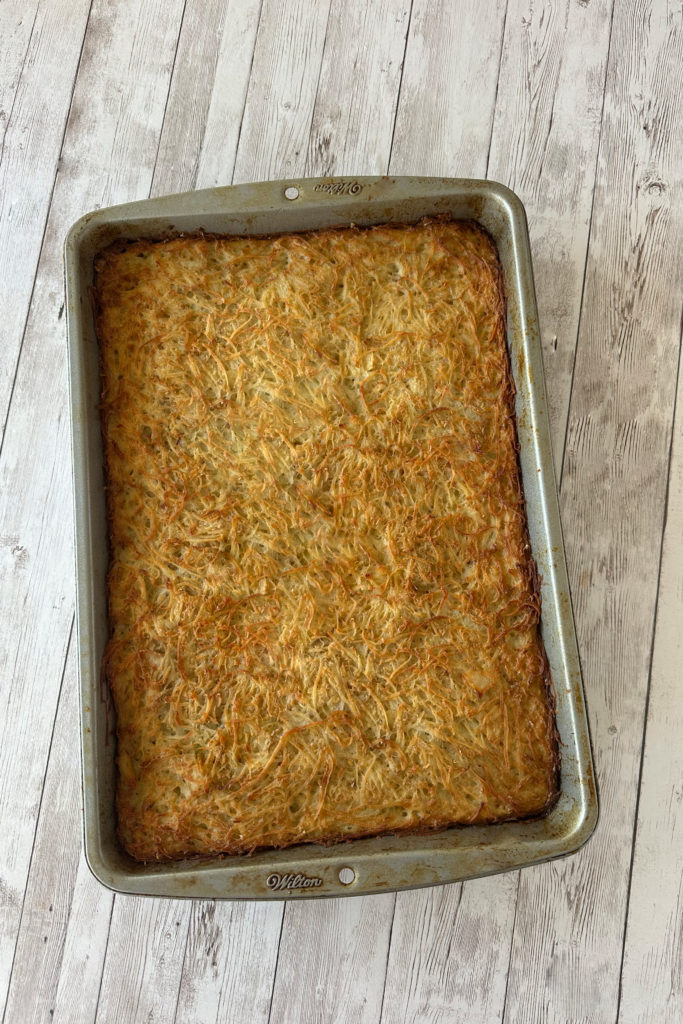 Easy potato kugel in a pan on a white wood table