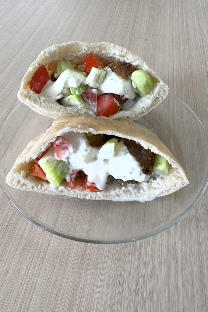 Israeli falafel balls in two pita halves with Israeli salad and tehini