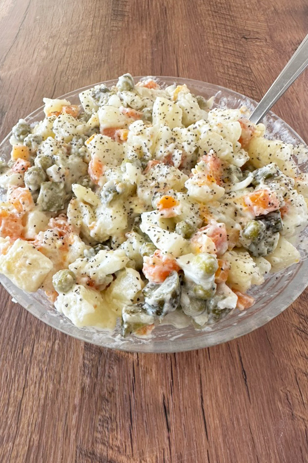 Israeli Potato salad in a clear bowl on a dark wood table