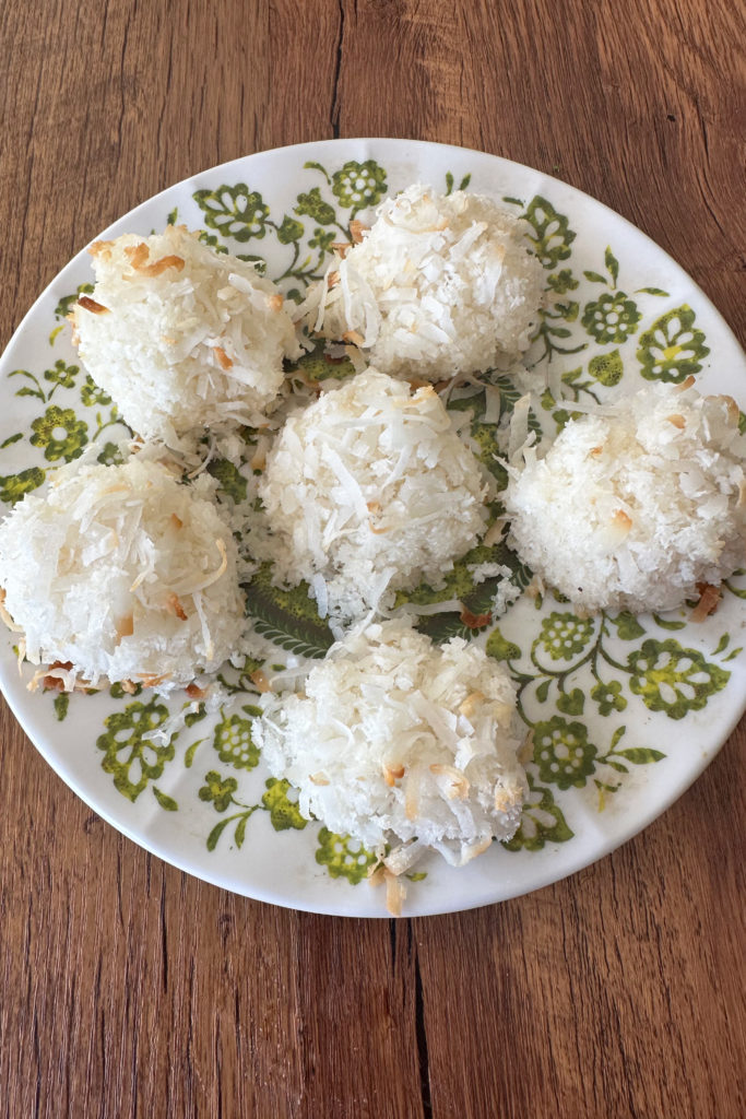 easy coconut Macaroons on a green and white plate on a dark wood table
